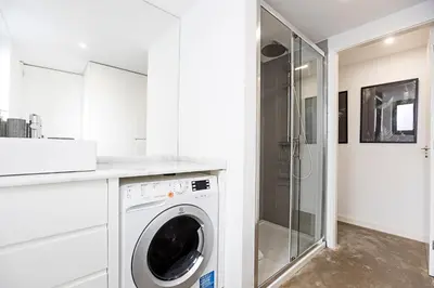 a white kitchen with a washing machine in a bathroom at Cozy House w/ AC near metro by LovelyStay in Porto