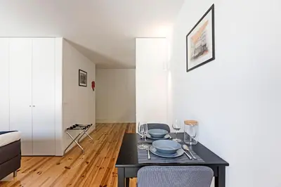 a dining room with a table with plates and glasses at Lapa Flat in City Center by LovelyStay in Porto
