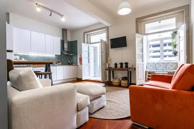 a living room with two couches and a kitchen at Bonjardim Deluxe Loft in Porto