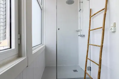 a glass shower stall with a ladder in a bathroom at Bonjardim Deluxe Loft in Porto