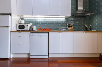a kitchen with white cabinets and a white refrigerator at Bonjardim Deluxe Loft in Porto