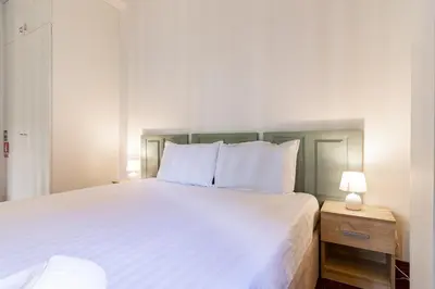a bedroom with a large white bed with two lamps at Bonjardim Deluxe Loft in Porto