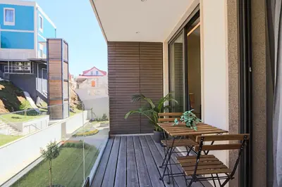 a balcony with a wooden table and chairs at HM - Casa Ghiselini Porto 214 in Porto
