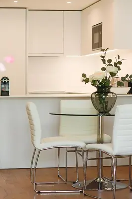 a dining room table with white chairs and a vase of flowers at HM - Casa Ghiselini Porto 214 in Porto