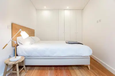 a bedroom with a bed with a lamp and a table at Downtown Wonder Flat w/ AC by LovelyStay in Porto