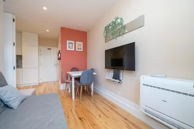 a living room with a table and a flat screen tv at Firmeza Apartment by Amber Star Rent in Porto