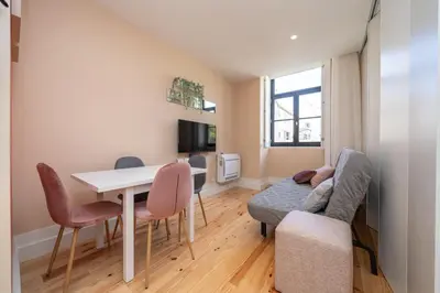 a small living room with a table and chairs at Firmeza Apartment by Amber Star Rent in Porto