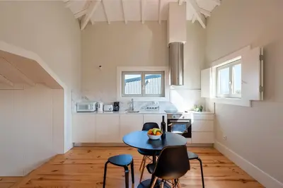 a kitchen with a table and chairs in a room at Oporto Rooftop Studio by Vacationy in Porto