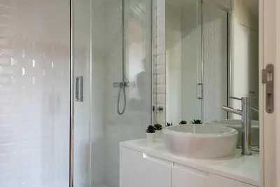a white bathroom with a sink and a shower at Oporto Rooftop Studio by Vacationy in Porto