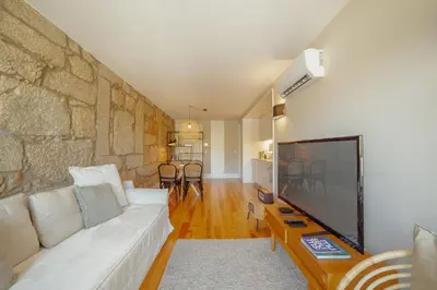a living room with a white couch and a tv at Boavista Premium Apartments by Vacationy in Porto