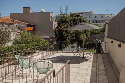 a patio with a table and chairs and an umbrella at Legacy Oporto Premium Apartments by Vacationy in Porto