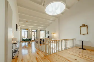 an open living room with a staircase and a large window at Legacy Oporto Premium Apartments by Vacationy in Porto
