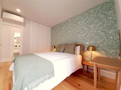 a bedroom with a bed and a green wall at Davis Home, Refúgio de Charme no Porto in Porto