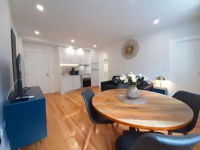 a living room with a table with chairs and a television at Davis Home, Refúgio de Charme no Porto in Porto