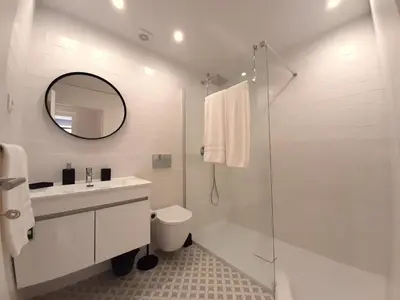 a white bathroom with a sink and a shower at Davis Home, Refúgio de Charme no Porto in Porto
