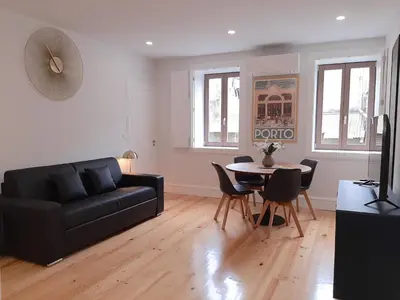 a living room with a black couch and a table at Davis Home, Refúgio de Charme no Porto in Porto