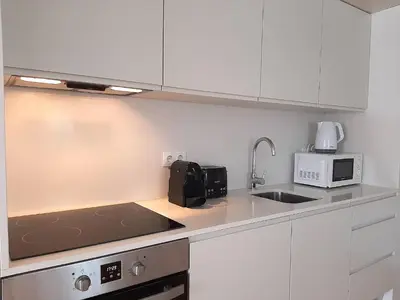 a kitchen with white cabinets and a sink and a microwave at Porto Vista by Flat in Porto in Porto