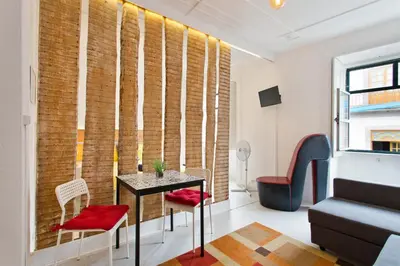 a room with a table and chairs in front of a brick wall at Oporto Blue Vitória - Lovely Citycenter Studio in Porto