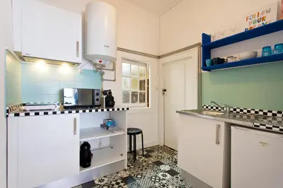 a kitchen with white cabinets and a tile floor at Oporto Blue Vitória - Lovely Citycenter Studio in Porto