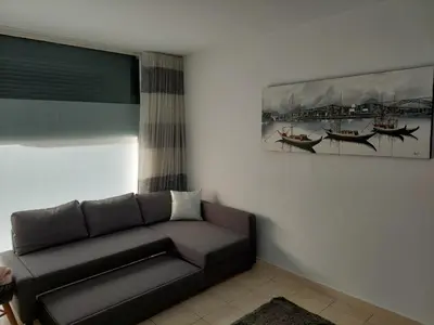 a living room with a couch and a picture of boats at charming loft in Porto in Porto