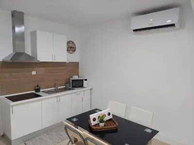 a kitchen with white cabinets and a table and a sink at charming loft in Porto in Porto
