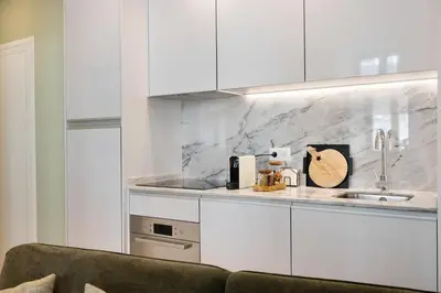 a kitchen with white cabinets and a sink at Away to Enjoy Apartment - hapiness has a place in Porto