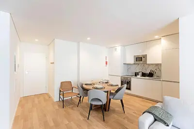 a kitchen and a dining room with a table and chairs at Paraíso -1B w/ AC & Patio by LovelyStay in Porto