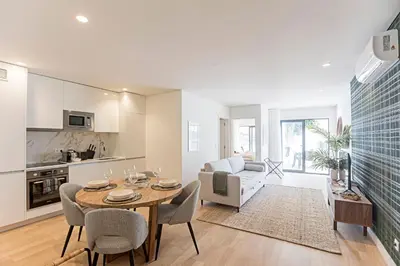 a kitchen and living room with a table and chairs at Paraíso -1B w/ AC & Patio by LovelyStay in Porto