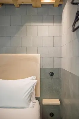 a bed with a white pillow next to a shower at 62 Design House II in Porto