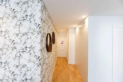 a hallway with a wall with floral wallpaper at NEW Cozy and Modern Apartment in the heart of Porto in Porto