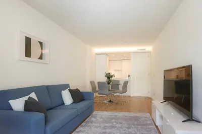 a living room with a blue couch and a television at HM - Casa Ghiselini Porto 213 in Porto