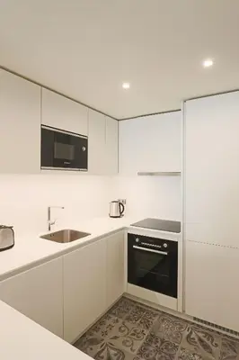 a white kitchen with a sink and a microwave at HM - Casa Ghiselini Porto 213 in Porto