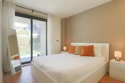 a bedroom with a white bed and a large window at HM - Casa Ghiselini Porto 215 in Porto