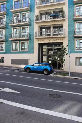 a blue car parked in front of a building at HM - Casa Ghiselini Porto 215 in Porto