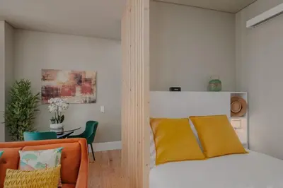 a bedroom with a bed and a chair and a table at Green Garden Luxury House w/ AC, Metro & Downtown in Porto