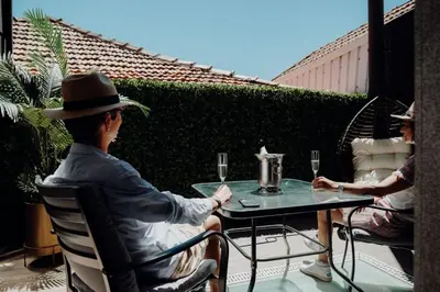 two people sitting at a table on a patio at Green Garden Luxury House w/ AC, Metro & Downtown in Porto