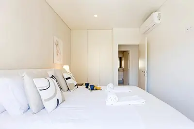 a bedroom with a white bed with white pillows at Paraíso 1H w/ AC by LovelyStay in Porto