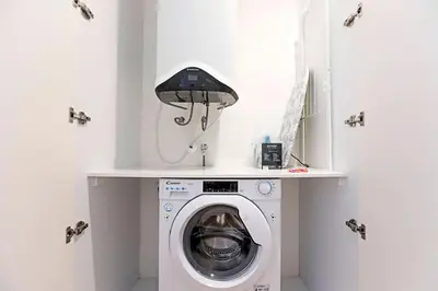 a laundry room with a washing machine and a lamp at Paraíso 1H w/ AC by LovelyStay in Porto