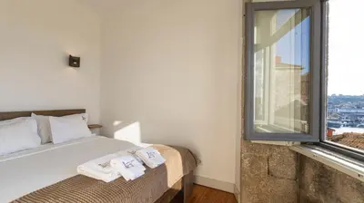 a bedroom with a bed and a large window at Authentic Porto House in Porto