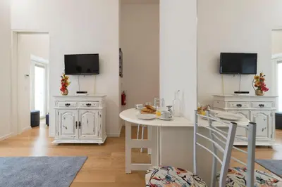 a living room with a white table and a tv at Santo António Oporto House in Porto