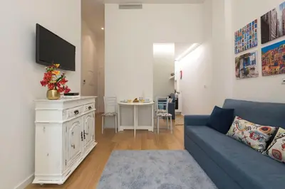 a living room with a couch and a tv on a wall at Santo António Oporto House in Porto