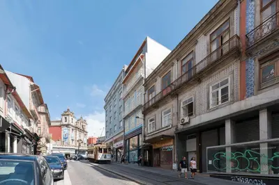 a city street with buildings and a tram at Santo António Oporto House in Porto
