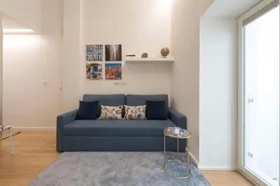 a blue couch in a living room with a table at Santo António Oporto House in Porto