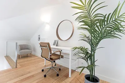 a desk with a chair and a mirror and a plant at Stunning Duplex Near River by LovelyStay in Porto