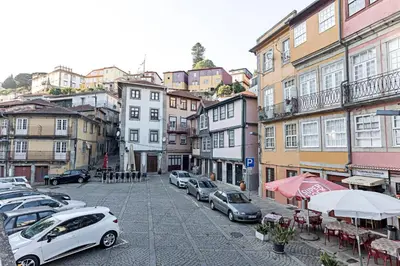 a city street with parked cars and buildings at Stunning Duplex Near River by LovelyStay in Porto