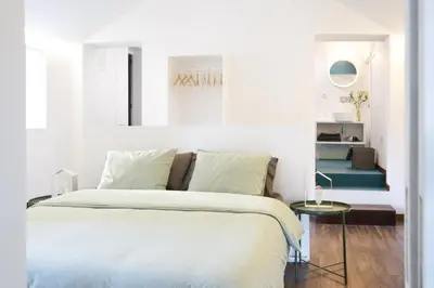 a white bedroom with a bed and a table at Alegria Cool House in Porto