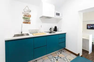a kitchen with blue cabinets and a sink at Alegria Cool House in Porto