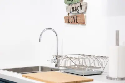 a kitchen sink with a dish drying rack next to it at Alegria Cool House in Porto