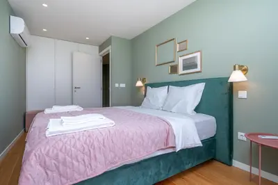 a bedroom with a large bed with a pink blanket at Trindade Duplex by Amber Star Rent in Porto
