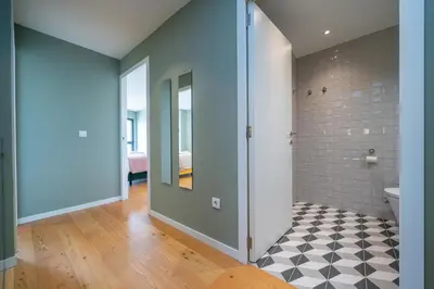 a bathroom with a shower and a tile wall at Trindade Duplex by Amber Star Rent in Porto